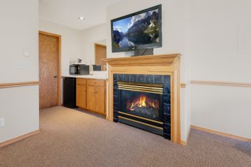 fireplace, kitchenet, and TV mounted on wall