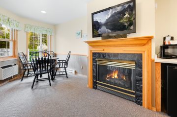 TV mounted above fireplace and table