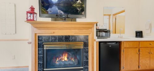 Fireplace with TV above and mini fridge on side