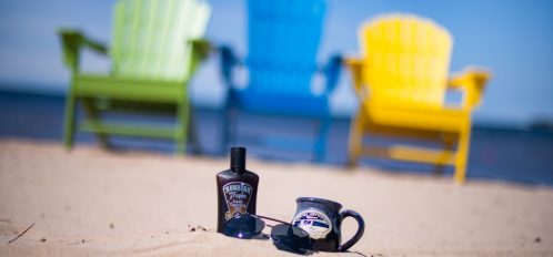 Coffee Mug, Sunscreen, and beach chairs on beach