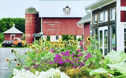 Orchard county winery and cider mill bright red building with flowers outside